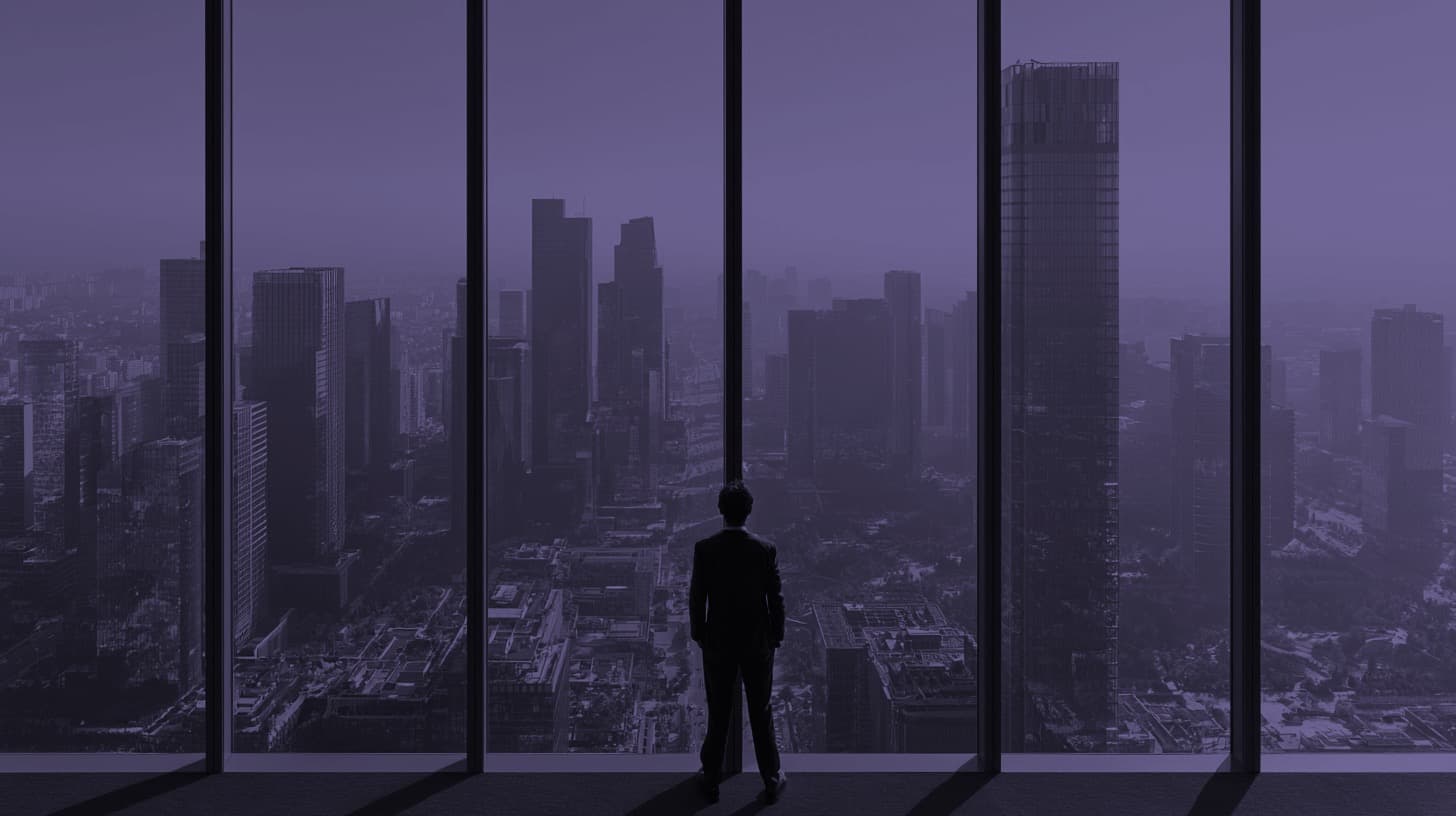 A leader looking out over a city skyline at dusk